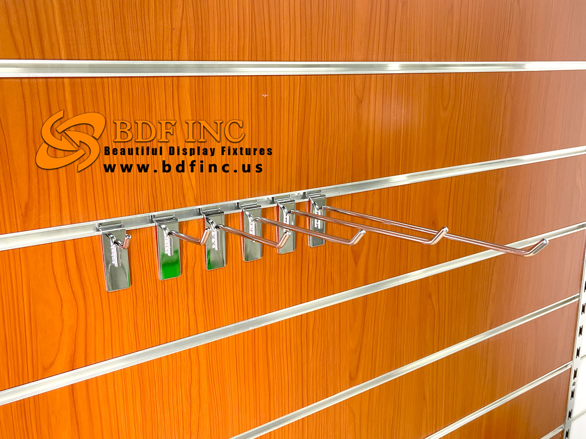 Multiple chrome slatwall hooks mounted on panel for merchandise display