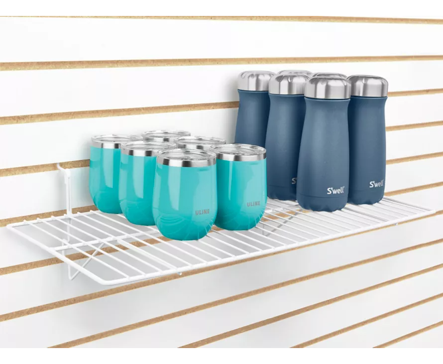 Spacious 12x24 inch white wire shelf installed on white slatwall, creating a bright display for multiple pairs of shoes.