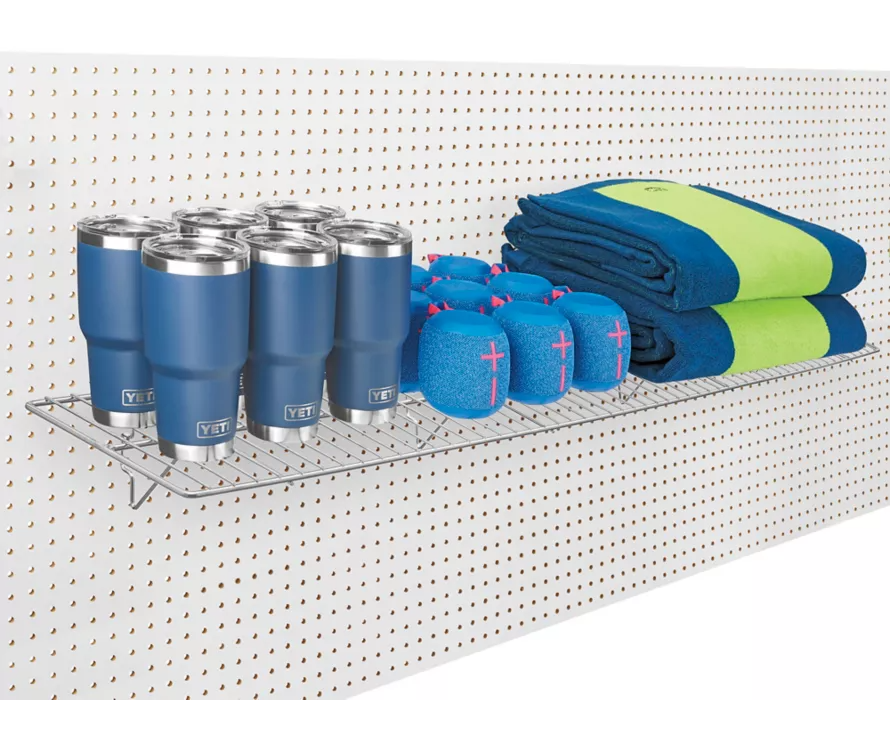 Heavy-duty 12x48 inch chrome slatwall wire shelf installed on gridwall, perfect for boutique fashion and accessory displays.