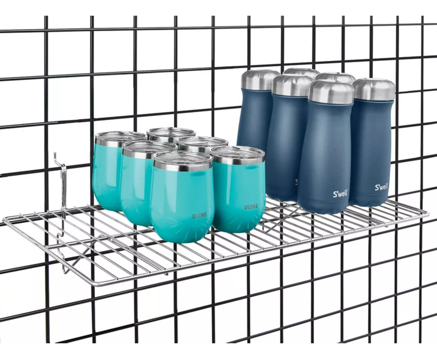 Large 12x24 inch chrome shelf installed on wire gridwall, providing a sleek and modern display for handbags and fashion items.