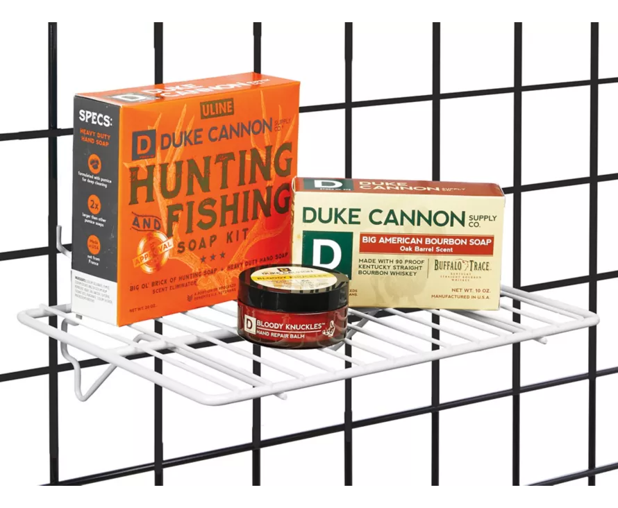 Clean white wire shelf installed on white gridwall, providing a bright and airy display for fashion accessories and retail products.